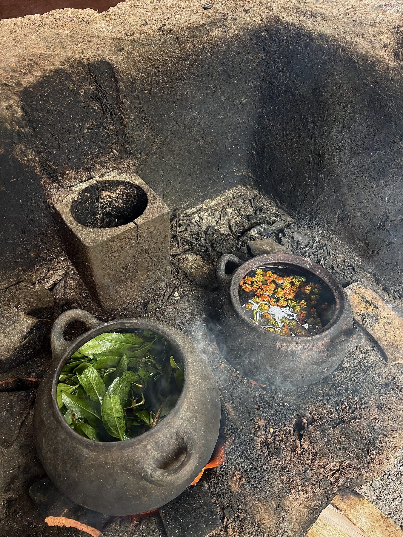 Inside the workshop in Chinchero — clay pots simmering plant dyes over a wood fire
