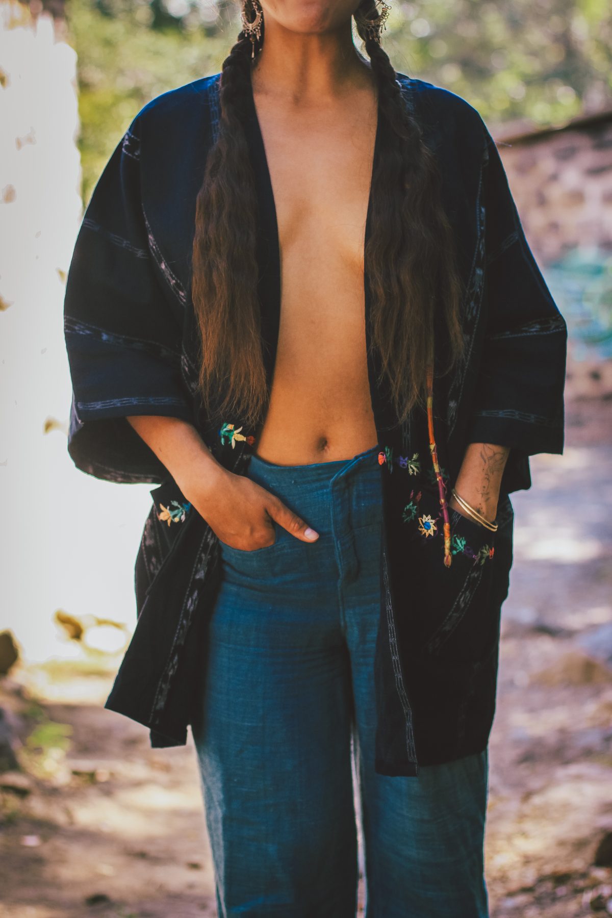 A spread of Ixoq pieces — scarves, shawls, bags, pillowcases, and kimonos in vivid backstrap-woven cotton